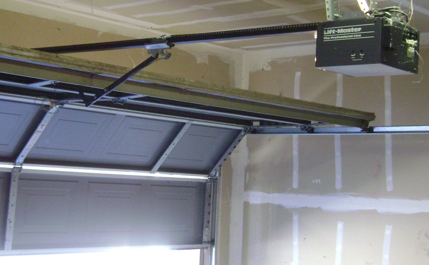 Chain-drive garage door opener mounted inside a garage